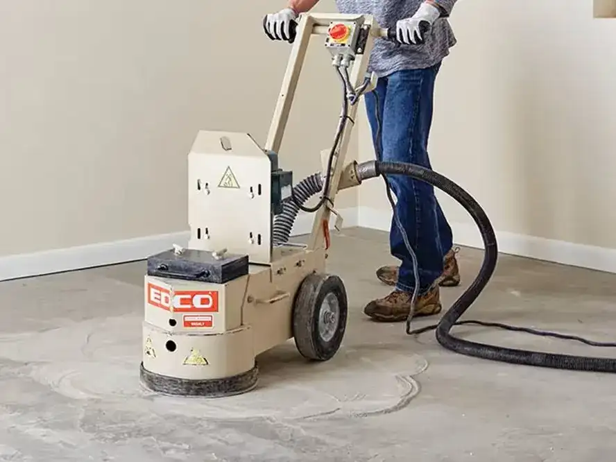 A concrete slab prepared for flooring: ground flat, levelled to a screed line, with a snapped chalk line and a saw-cut control joint.